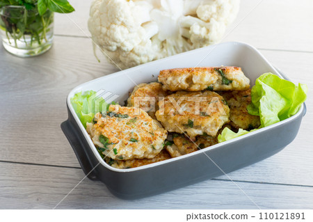 cooked vegetarian fried cauliflower cutlets in a ceramic form . 110121891