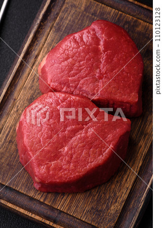 Fresh juicy raw filet mignon with salt, spices and herbs Fresh juicy raw filet mignon with salt, spices and herbs 110123128