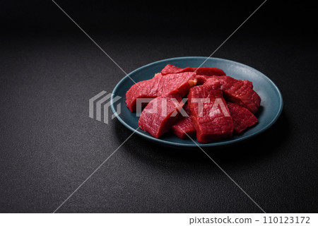 Juicy fresh raw beef meat with salt, spices and herbs Juicy fresh raw beef meat with salt, spices and herbs 110123172
