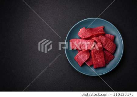 Juicy fresh raw beef meat with salt, spices and herbs Juicy fresh raw beef meat with salt, spices and herbs 110123173