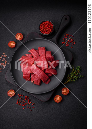 Juicy fresh raw beef meat with salt, spices and herbs Juicy fresh raw beef meat with salt, spices and herbs 110123198