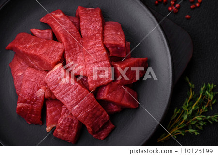 Juicy fresh raw beef meat with salt, spices and herbs Juicy fresh raw beef meat with salt, spices and herbs 110123199