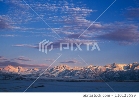 winter landscape with the Tien Shan mountains in Kazakhstan in the snow in the steppe under blue sky with clouds at sunset 110123559