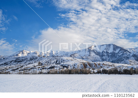winter landscape with the Tien Shan mountains in Kazakhstan in snow under blue sky with clouds 110123562