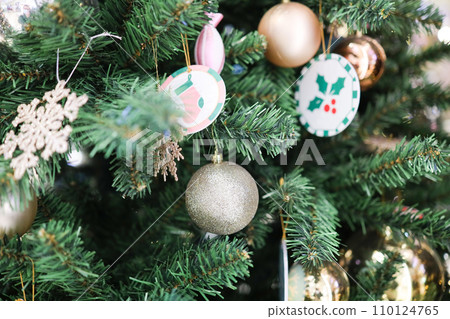 a Festive Christmas tree ornament hanging on evergreen tree 110124765