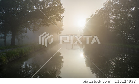 Misty Dawn Reflections by the Riverside 110124958