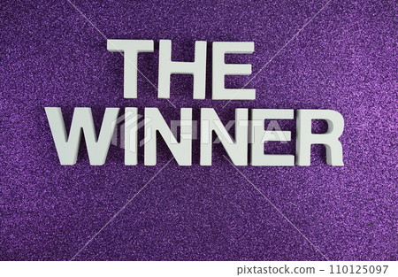 The Winner alphabet letters top view on purple glitter background The Winner alphabet letters top view on purple glitter background 110125097