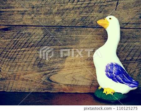 decorative statue of duck with space on wooden background decorative statue of duck with space on wooden background 110125275