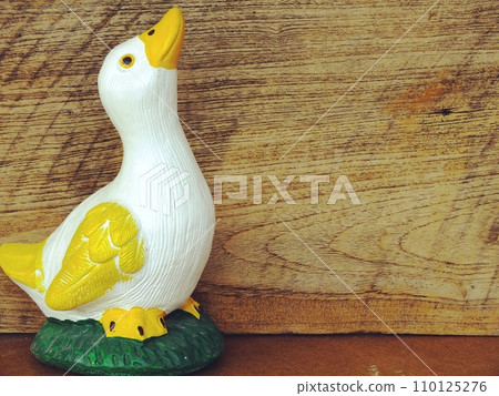 decorative statue of duck with space on wooden background decorative statue of duck with space on wooden background 110125276