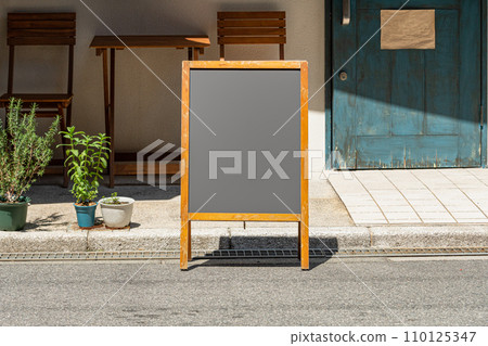 Blank white outdoor advertising stand/sandwich board mock up template. Clear street signage board placed by an outdoor dinning area of a restaurant. Background texture of standee on street. Blank white outdoor advertising stand/sandwich board mock up template. Clear street signage board placed by an outdoor dinning area of a restaurant. Background texture of standee on street. 110125347
