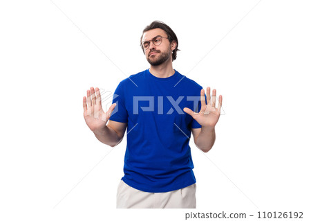 30 year old European guy with black hair and a beard in a blue T-shirt gesturing with his hands 110126192