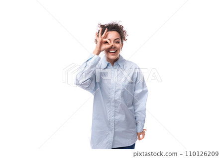 charming young brunette curly business woman in a blue shirt on a white background with copy space 110126209