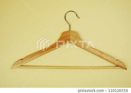 Wooden hanger top view on yellow background 110126558