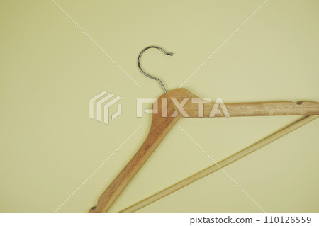 Wooden hanger top view on yellow background Wooden hanger top view on yellow background 110126559