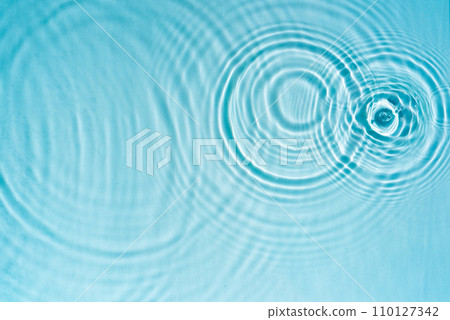 Texture of blue transparent water with splashes. Aqua texture with drops and ripples. Cosmetic micellar spray Texture of blue transparent water with splashes. Aqua texture with drops and ripples. Cosmetic micellar spray 110127342