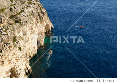 BLUE GROTTO, MALTA - 03 JAN, 2020: A cruise board next to Blue Grotto. This is one of the attractions of the island of Malta 110127404