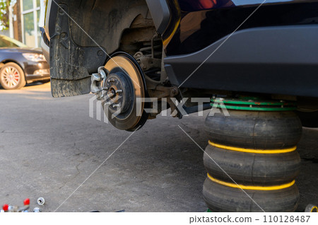 A pneumatic jack supports the vehicle while changing tires. 110128487