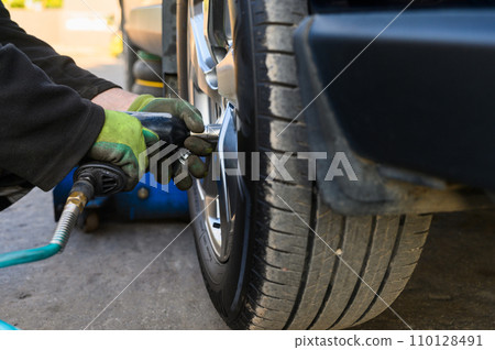 Car mechanic changing wheels in car Car mechanic changing wheels in car 110128491