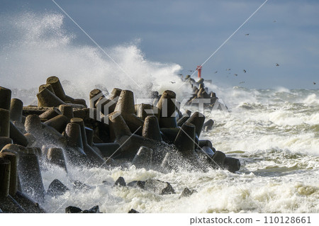 Big wave breaking on breakwater, stormy sea, crashing waves, wave splashing, hurricane season Big wave breaking on breakwater, stormy sea, crashing waves, wave splashing, hurricane season 110128661