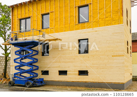Using a scissor lift in facade cladding works after spraying the facade with thermal insulation foam 110128665