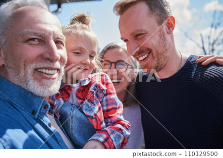 Happy family of three generations posing at camera together Happy family of three generations posing at camera together 110129500