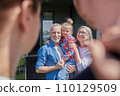 Senior couple holding little girl at the hands and feeling happy at the summer 110129509
