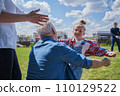 Small child girl embracing her senior grandfather while meeting him 110129522
