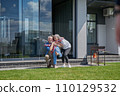 Back view of the small child girl embracing her senior grandparents 110129532