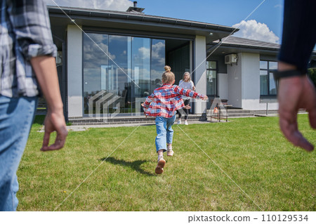 Back view of the little kid girl running to her senior grandfather Back view of the little kid girl running to her senior grandfather 110129534