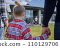 Little girl holding hands of father and mother while meeting her senior grandparents 110129706