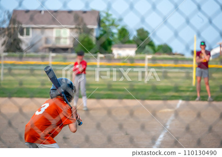 Parent view behind a chain link fence and home plate with a batter ready Parent view behind a chain link fence and home plate with a batter ready 110130490