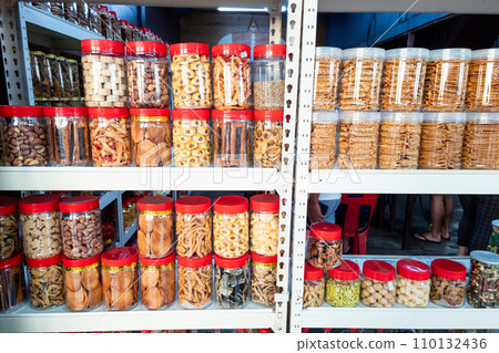 Variety of Chinese New Year cookies in jars place on shelf of retail for sale 110132436