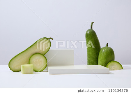 Over white background, geometric shaped podiums displayed with winter melon slices. Research indicates that Winter melon (Benincasa hispida) is rich in polyphenols Over white background, geometric shaped podiums displayed with winter melon slices. Research indicates that Winter melon (Benincasa hispida) is rich in polyphenols 110134276