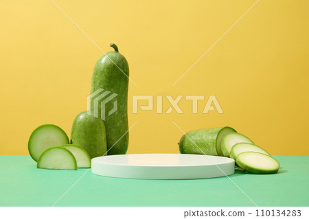 White podium with vacant space featured over yellow with slices of winter melon. Minimal podium display for cosmetic product presentation of Winter melon (Benincasa hispida) extract White podium with vacant space featured over yellow with slices of winter melon. Minimal podium display for cosmetic product presentation of Winter melon (Benincasa hispida) extract 110134283