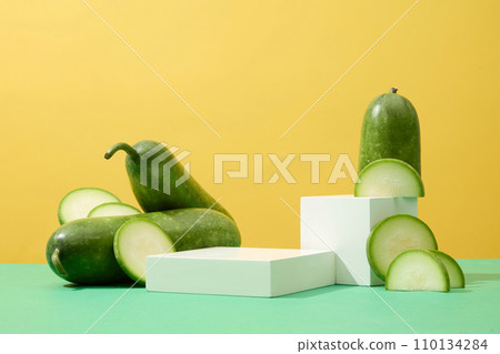 Two podiums in white color arranged on green surface with winter melon. Concept scene stage showcase for new product, promotion sale, cosmetic presentation Two podiums in white color arranged on green surface with winter melon. Concept scene stage showcase for new product, promotion sale, cosmetic presentation 110134284
