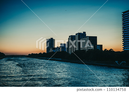 River and high-rise apartment complex at sunset River and high-rise apartment complex at sunset 110134758