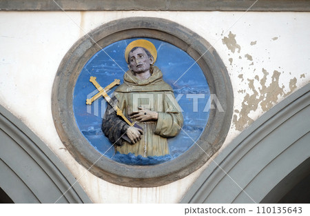 St. Francis of Assisi, glazed terracotta tondo by Andrea della Robbia, located between two arches of the old Ospedale di San Paolo, in Florence, Italy 110135643