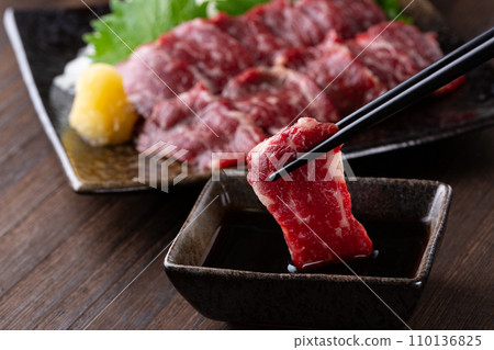 Eating horse sashimi with chopsticks Eating horse sashimi with chopsticks 110136825