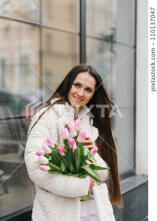 Candid portrait of happy woman with tulips bouquet outdoors Candid portrait of happy woman with tulips bouquet outdoors 110137047