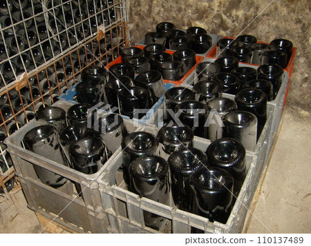 wine dusty bottles upside down in a box for storing and brewing wine. Wine cellar equipment. The process of making expensive French wine. Dust on a Dark Glass Bottle. wine dusty bottles upside down in a box for storing and brewing wine. Wine cellar equipment. The process of making expensive French wine. Dust on a Dark Glass Bottle. 110137489