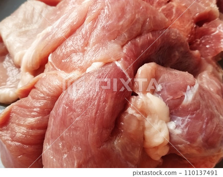 A juicy large piece of pork meat on a gray surface. Meat thawed or steamed, from which blood juice flows. Delicious fresh meat for cutting and cooking A juicy large piece of pork meat on a gray surface. Meat thawed or steamed, from which blood juice flows. Delicious fresh meat for cutting and cooking 110137491