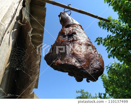 Meat. Homemade ham hanging on a hook. Dried smoked pork. Rustic food. Folk recipe. Turban, Fruska Mountain, Serbia. Home meat production. Farm 110137499