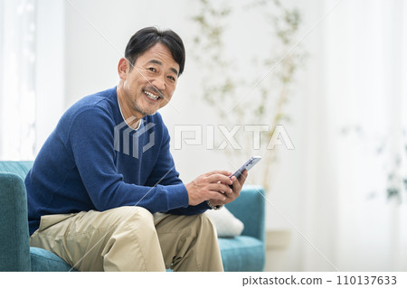 50 多歲的微笑男子拿著智慧型手機 110137633