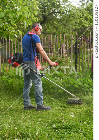 farmer mows the lawn grass with a lawn mower 110138127