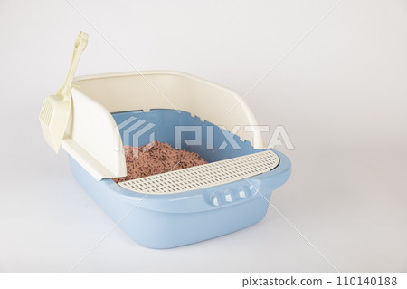 Ensure the hygiene and cleanliness of your cat's crate with an isolated plastic cat litter toilet tray and scoop on a white background. 110140188