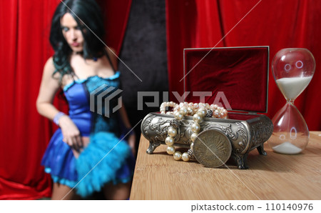 Jewelry Box and Hourglass With Woman in Blue Corset in Background Jewelry Box and Hourglass With Woman in Blue Corset in Background 110140976