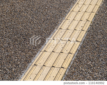 A sidewalk with Braille blocks. 110140992