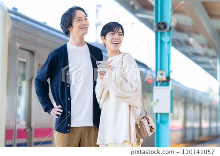 一對年輕夫婦在車站看智慧型手機。攝影由京王電鐵株式會社提供。 一對年輕夫婦在車站看智慧型手機。攝影由京王電鐵株式會社提供。 110141057
