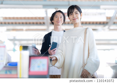 A young couple passing through the ticket gate using a smartphone. Photography provided by Keio Electric Railway Co., Ltd. A young couple passing through the ticket gate using a smartphone. Photography provided by Keio Electric Railway Co., Ltd. 110141072