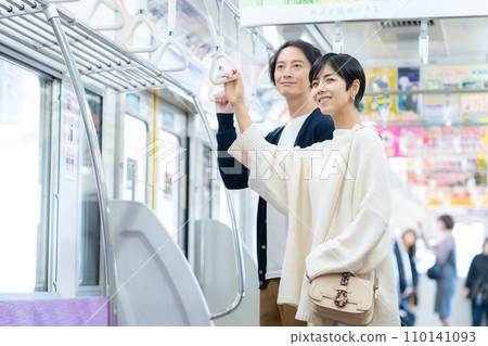 一對年輕夫婦搭火車約會。攝影由京王電鐵株式會社提供。 110141093
